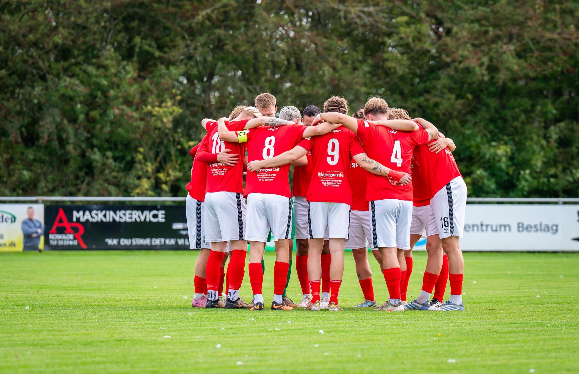 Såby Fodbolds herrehold samlet i en kreds på banen